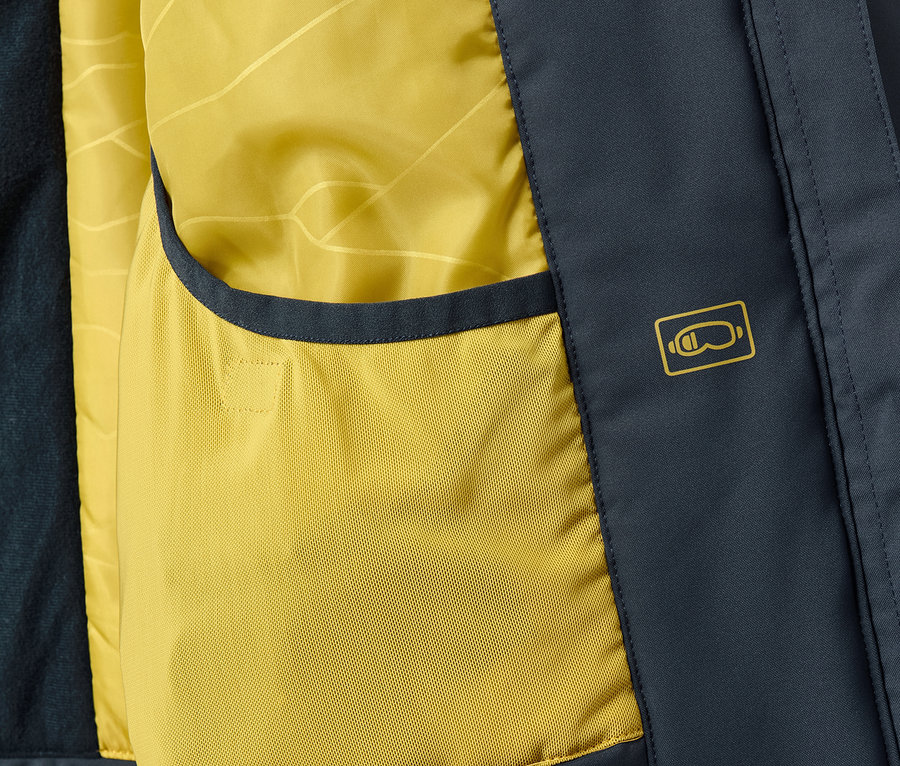 Detailansicht vom Innenraum einer High-Tech-Skijacke mit gelber Tasche und Aufdruck.