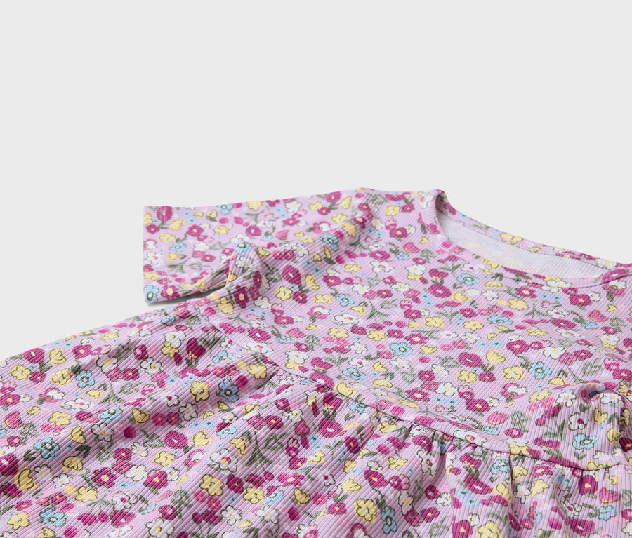 Detail eines lila Kleides mit Blumenmuster.