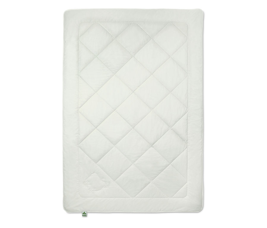 Eine weiße Steppdecke mit Rautenmuster.