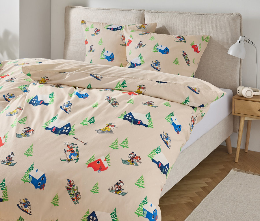 Bettwäsche mit Ski- und Baumdruck auf einem Bett.
