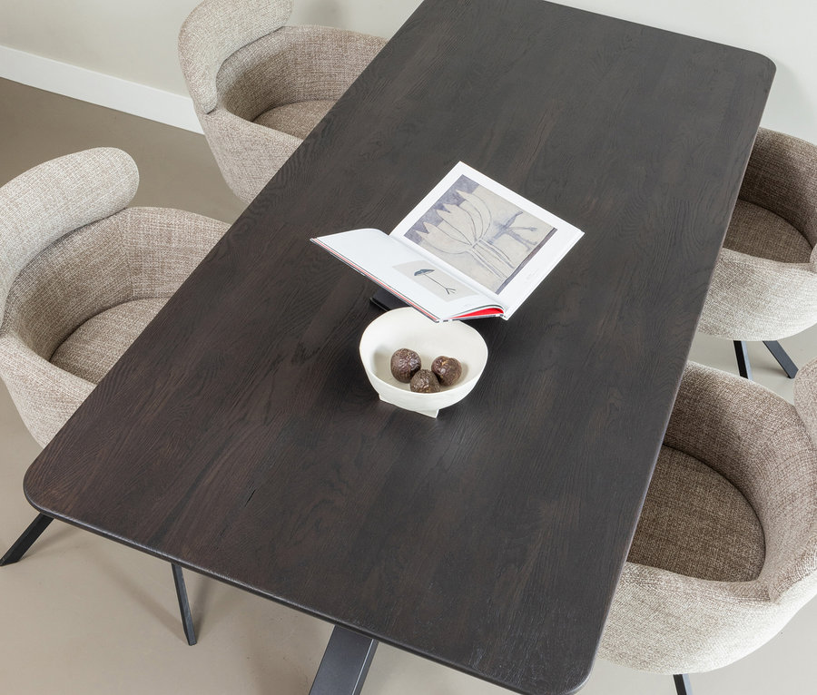 Vier naturfarbene Woood Stühle »Fenne« umgeben einen dunkelbraunen Tisch mit Buch und Schale.