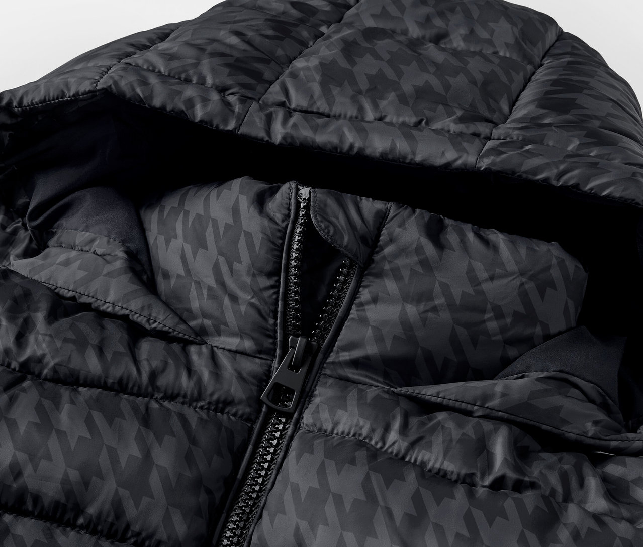 Detailaufnahme einer schwarzen Steppjacke mit Kapuze und Hahnentrittmuster, der Reißverschluss ist teilweise geöffnet.