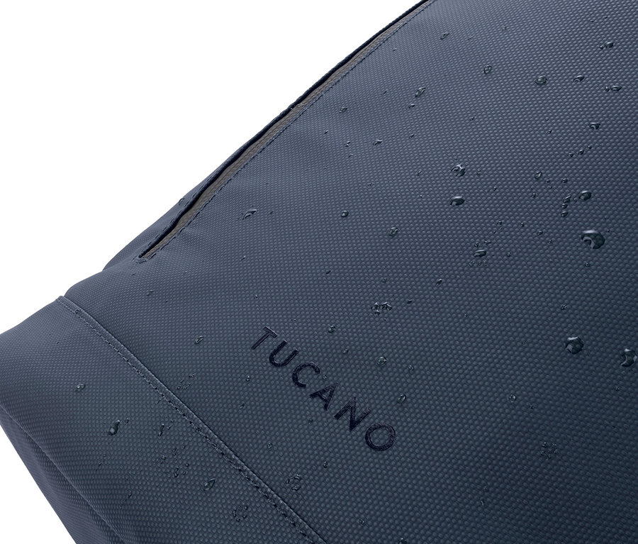 Detailaufnahme einer dunkelblauen TUCANO-Tasche mit Wassertropfen darauf.