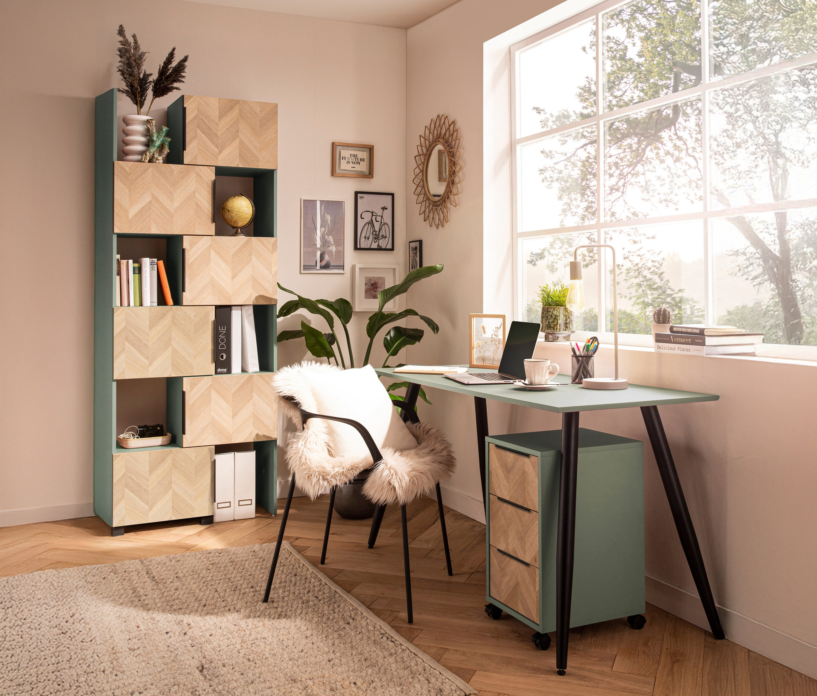 Ein Arbeitszimmer mit einem mintgrünen Schreibtisch, einem Bücherregal und einem Fenster.