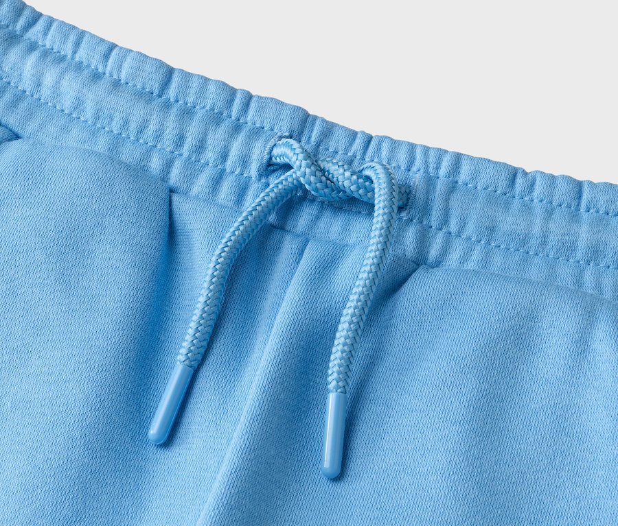 Nahaufnahme einer hellblauen Hose mit Kordelzug.
