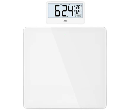 Weiße digitale Personenwaage mit separatem Display, das "62.4 kg", "26.0 °C", "64 %" Luftfeuchtigkeit und "21:06" anzeigt.