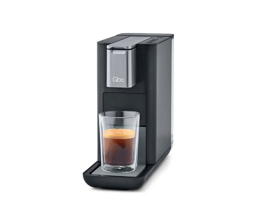 Qbo ESSENTIAL Dark Stone Kaffeemaschine mit Tasse Kaffee.
