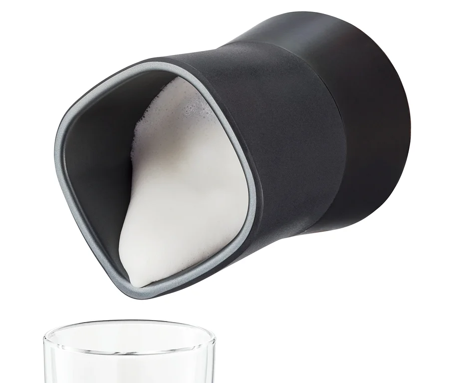Schwarzer elektrischer Milchaufschäumer gießt Milchschaum in ein Glas.