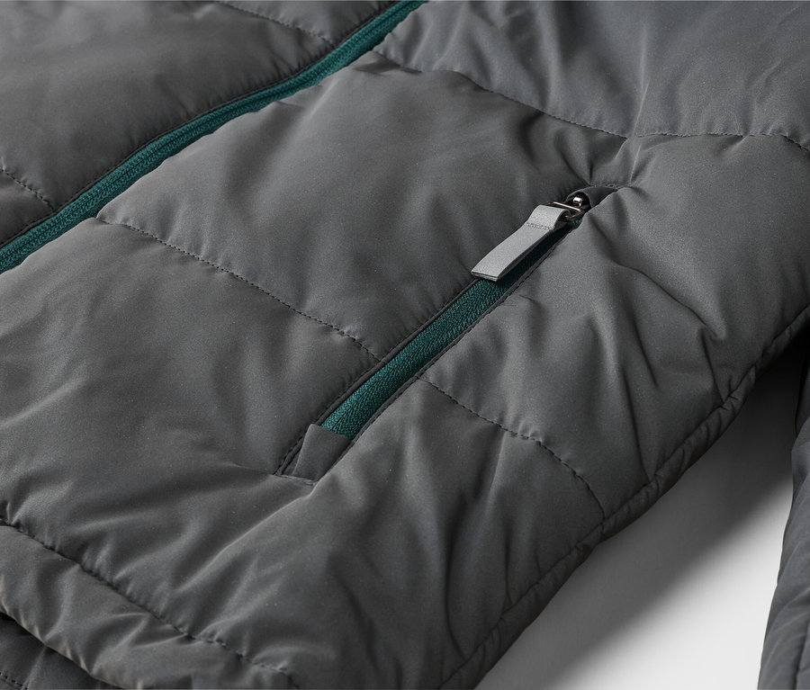 Dunkelgraue Steppjacke mit grünem Reißverschluss und grauem Reißverschluss-Schieber.