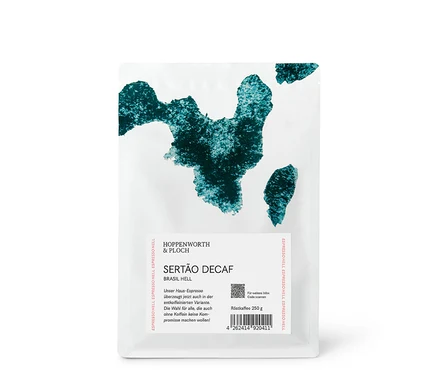 Weißer Kaffeebeutel mit abstraktem, türkisgrünem Muster oben. Aufschrift: HOPPENWORTH & PLOCH, SERTÃO DECAF, BRASIL HELL, Röstkaffee 250 g. QR-Code und Barcode sind sichtbar.