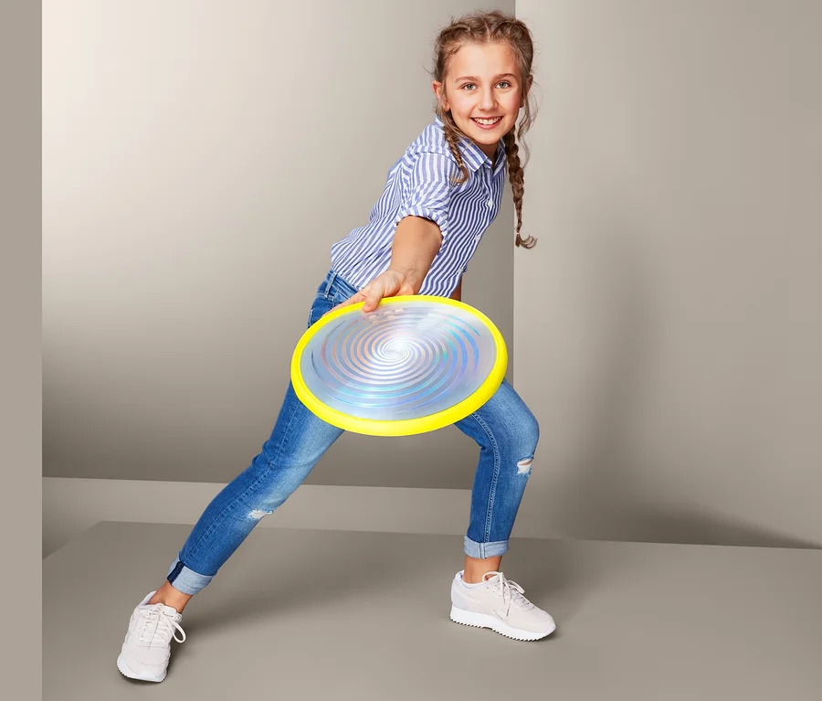 Mädchen wirft LED-Wurfscheibe.