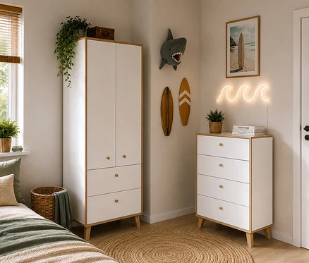 Ein Kinderzimmer im Surfer-Stil mit weißem und hölzernem Kleiderschrank und passender Kommode. Links ein Bett mit grüner Bettwäsche. Wanddeko umfasst ein Neon-Wellenzeichen, Surfbrett-Kunst und einen Haikopf. Ein runder Jute-Teppich liegt am Boden.