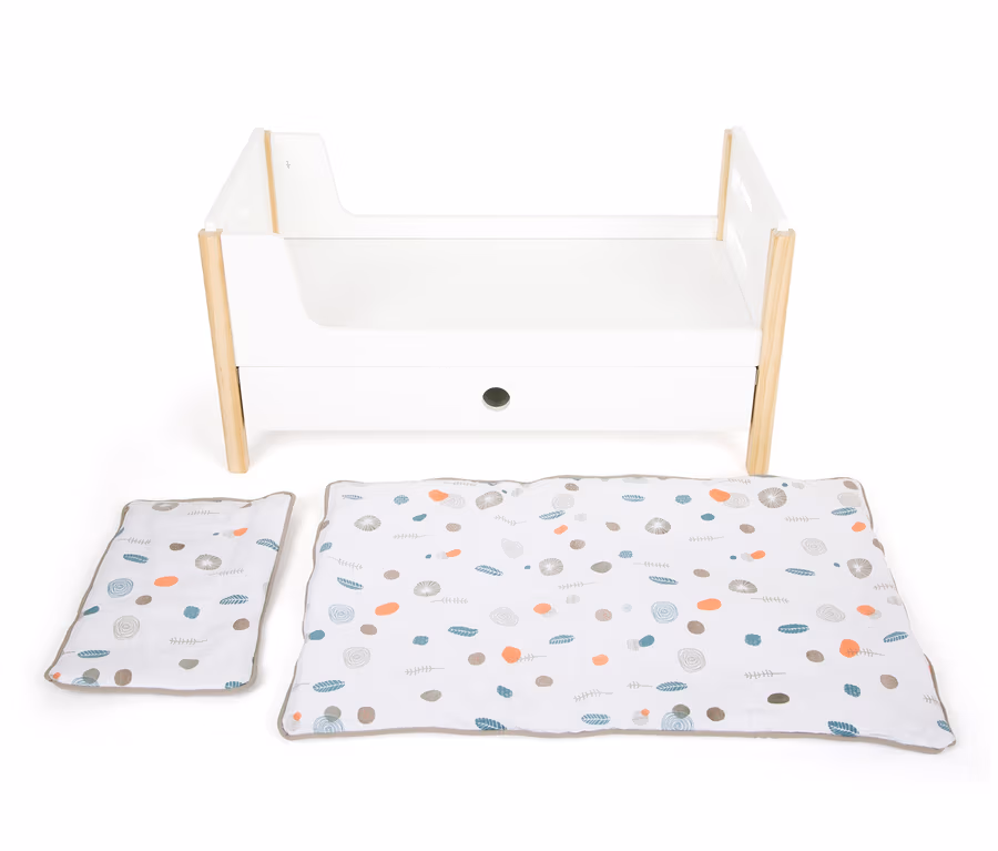 Ein weißes small foot Puppenhochbett »Little Button« mit Holzbeinen und einer weißen Decke und Kissen mit Aufdruck.