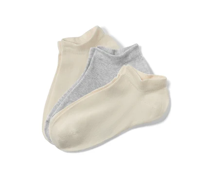 Nahaufnahme von drei Paar Kinder-Sneakersocken in Beige und Hellgrau.