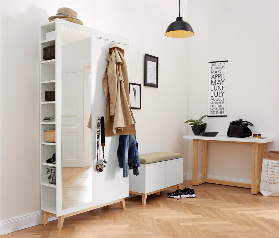 Im Flur stehen ein weißer Flurschrank und eine Sitzbank mit Stauraumfächern.