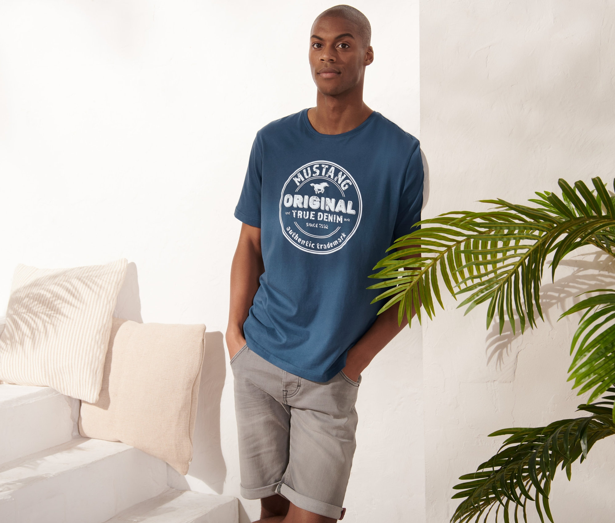 Mann posiert in blauem Mustang T-Shirt.
