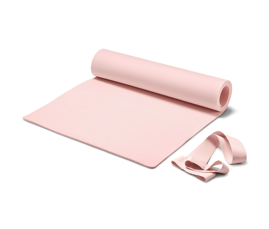 Eine teilweise aufgerollte rosa Yoga-und-Fitness-Matte mit einem Tragegurt auf einem weißen Hintergrund.