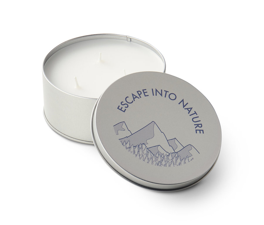 Geöffnete Metalldose mit Citronellakerze und Deckel mit der Aufschrift Escape into nature.