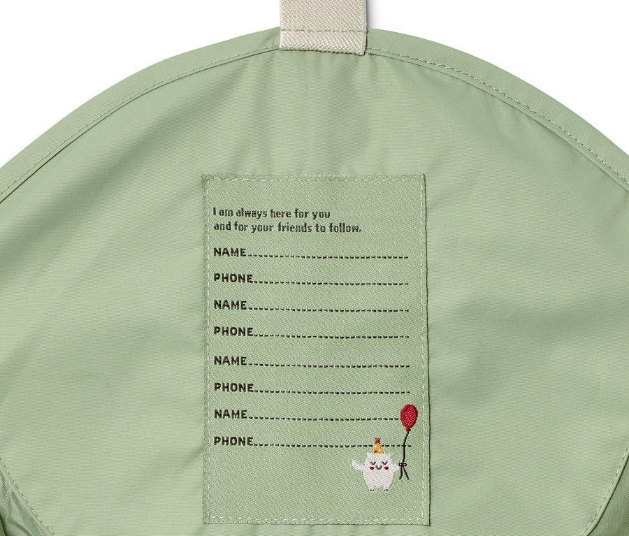 Grüne Regenhose mit Platz zum Eintragen von Name und Telefonnummer.