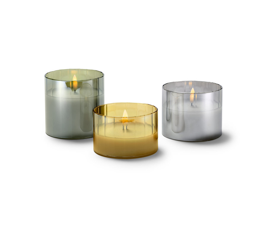 Drei LED-Echtwachskerzen im Glas in verschiedenen Farben.