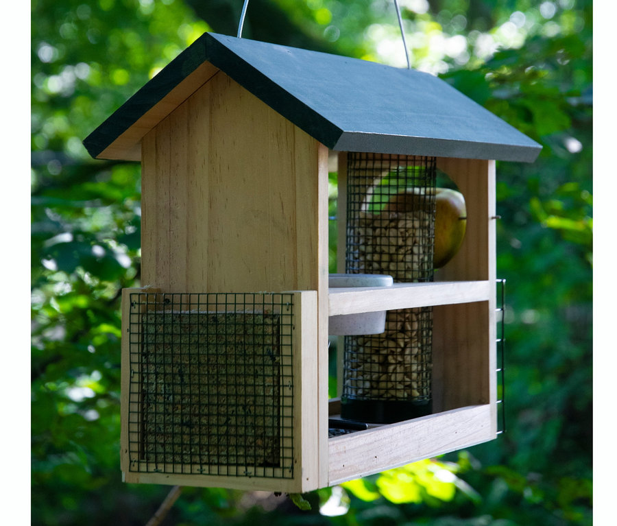 Ein hölzernes 7-in-1-Vogelhaus hängt an einem Baum.