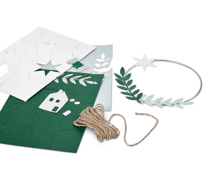 Dekokranz-Bastel-Set mit Papierhaus-, Stern- und Blätter-Ausschnitten, Bindfaden und Metallring.