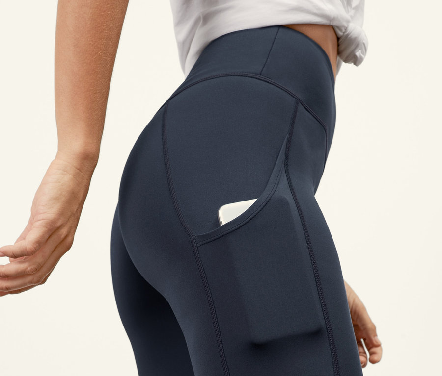 Detailaufnahme einer Frau, die eine »Pockets« Sporttight trägt, in deren Tasche ein weißes Mobiltelefon steckt.