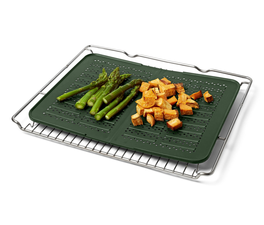Spargel und geschnittene Süßkartoffeln auf einem Silikon-Backblech auf einem Drahtgestell.