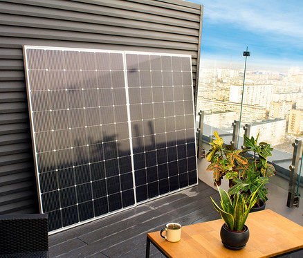 Zwei 600 W »TX220« Solar-Balkonkraftwerke lehnen an einer Wand auf einer Terrasse.