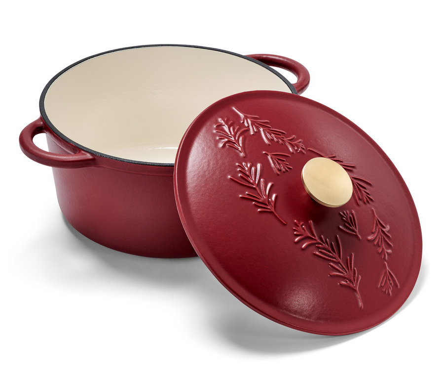 Ein roter Gusseisen-Topf mit einem Deckel, der ein geprägtes Zweigmuster aufweist.