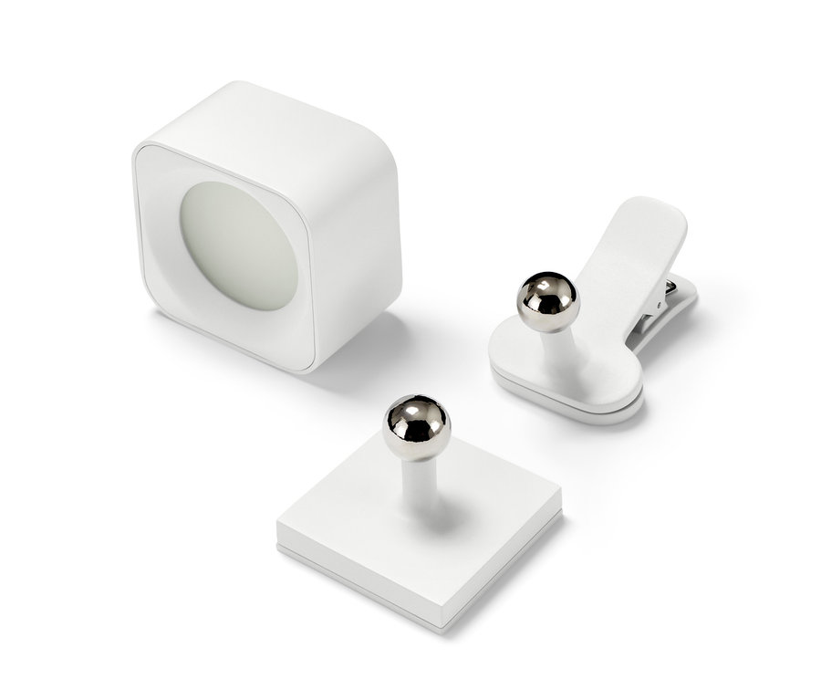 Eine LED-Akku-Wandleuchte, eine Magnethalterung und eine Klammer auf weißem Hintergrund.