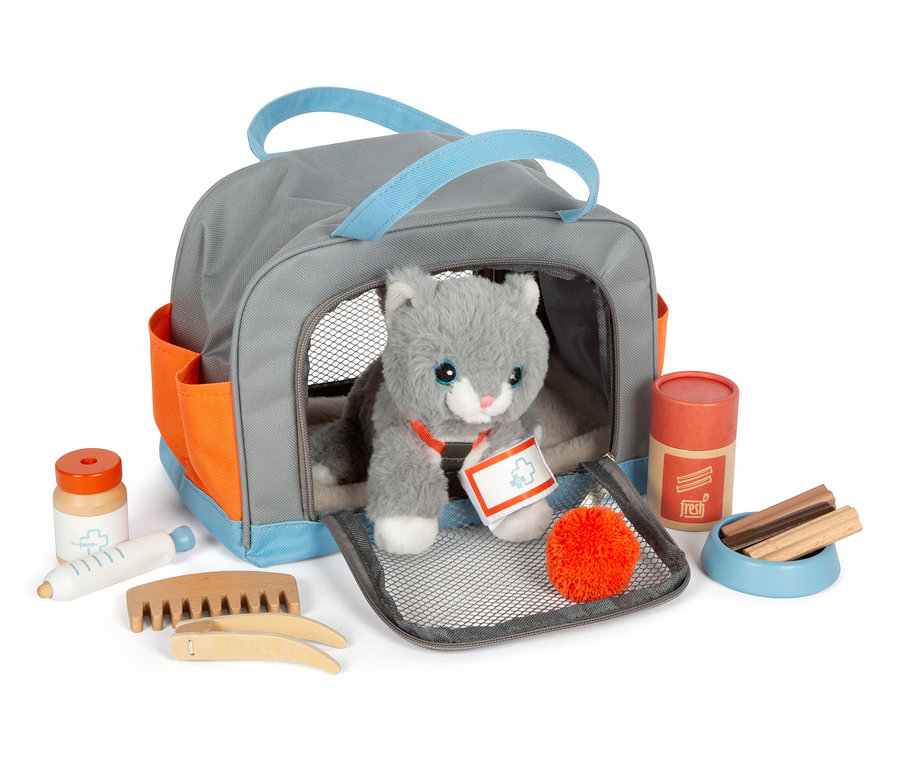 Graue small foot Tasche mit Plüschkatze und Pflege-Set. Die Katze sitzt in der Tasche, um sie herum liegen Pflegeutensilien.