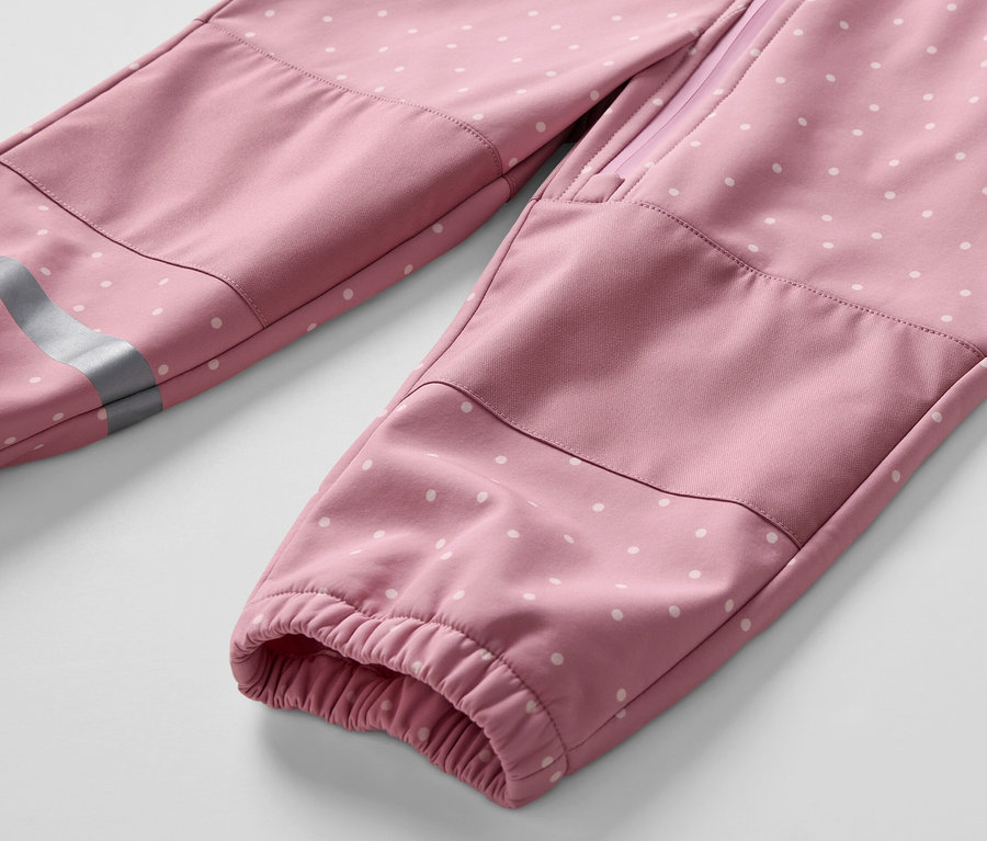 Detailaufnahme eines Kinder-Softshell-Einteilers mit weißen Punkten.