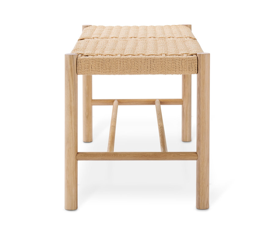 Eine Bank mit geflochtener Sitzfläche auf weißem Hintergrund.