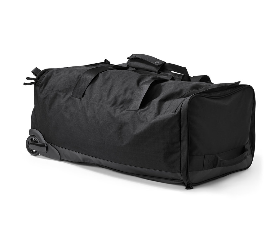 Eine schwarze Rollentasche mit Rucksackfunktion liegt auf der Seite.