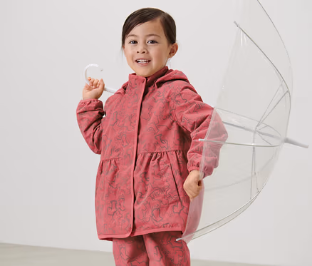 Mädchen hält einen durchsichtigen Regenschirm und trägt eine Kinder-Thermo-Regenjacke mit reflektierenden Elementen.