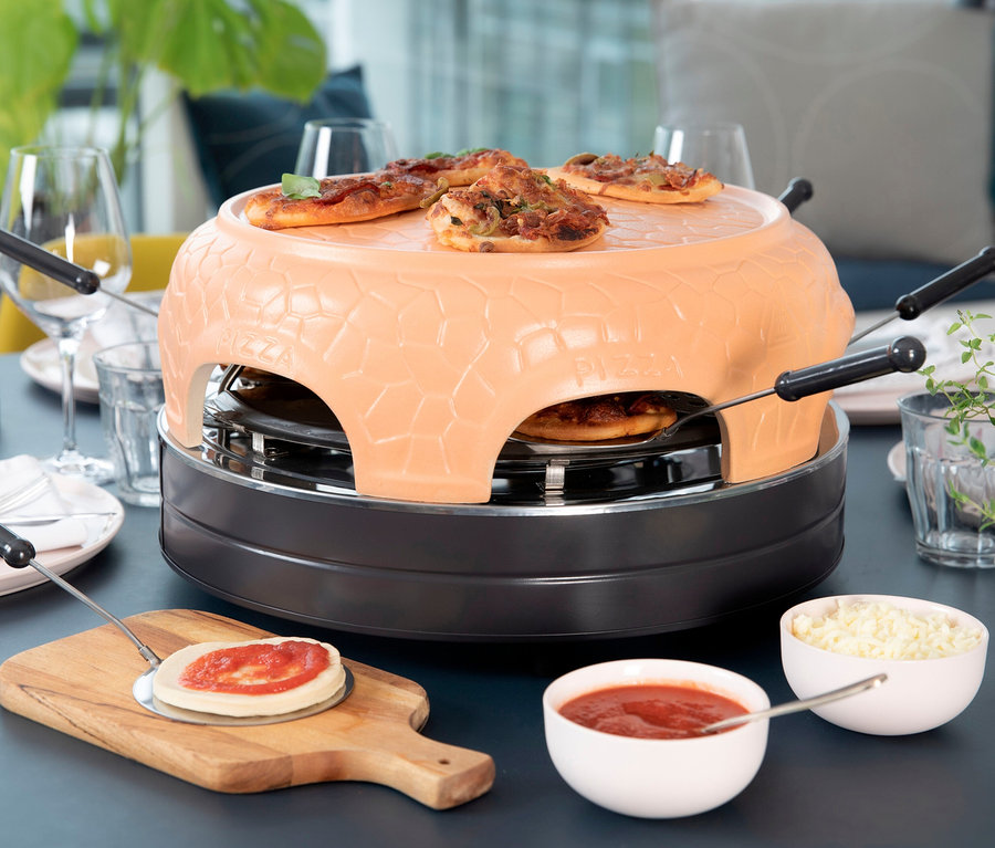 Pizza und Zutaten auf einem Tisch mit einem Pizzaofen.
