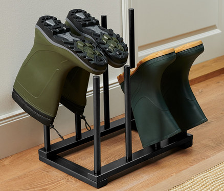 Zwei Paar grüne Gummistiefel in einem Stiefelhalter.