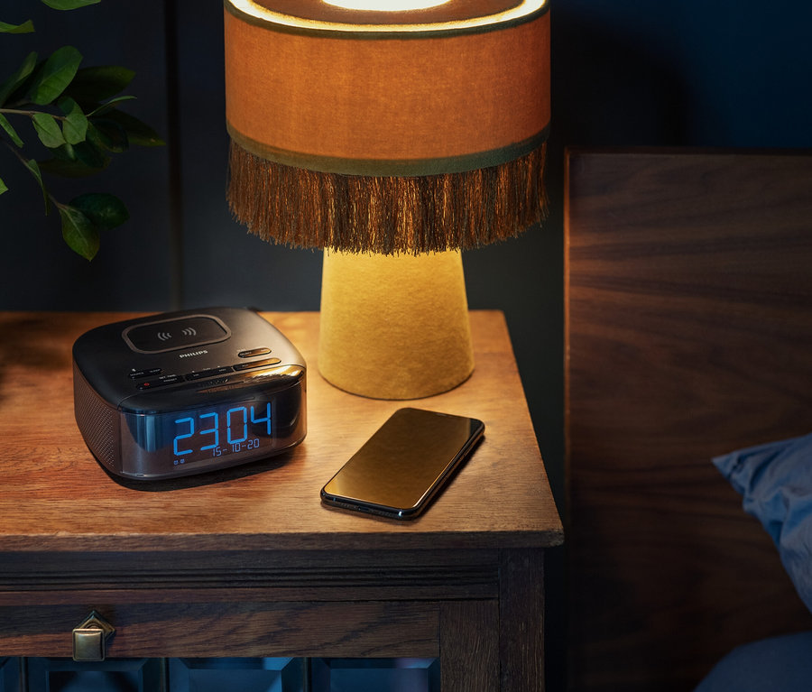 Auf einem Nachttisch stehen ein Philips DAB-Radiowecker »TAR7705«, ein Handy und eine Lampe.