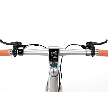 Lenker eines Sharp Hybrid E-Bikes mit Display und orangefarbenen Griffen.