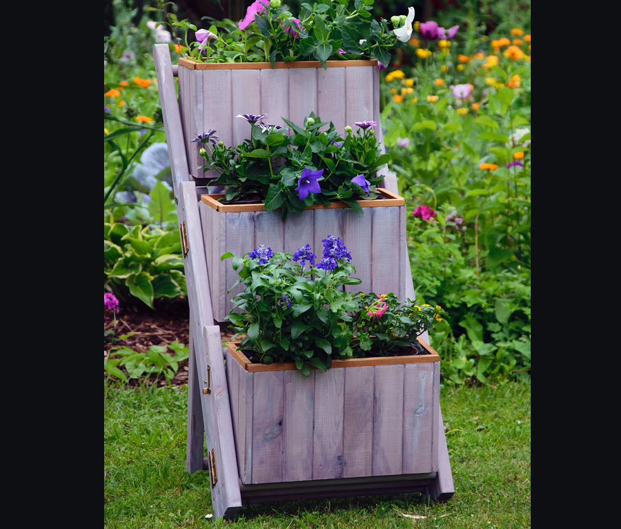 Eine graue Pflanzentreppe mit 3 Pflanzkästen im Garten.