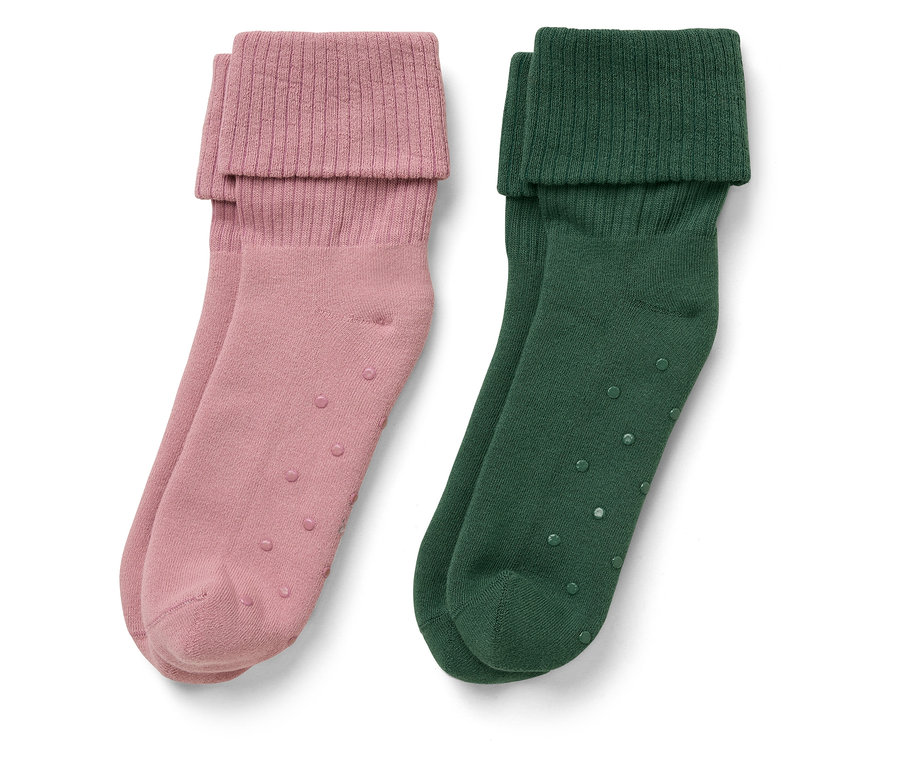Zwei Paar Socken: ein Paar rosa, ein Paar grün. Beide haben einen umgeschlagenen Rand und Anti-Rutsch-Punkte.