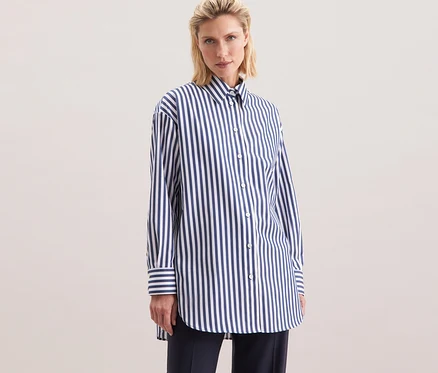 Frau trägt eine gestreifte Seidensticker Oversize Longbluse.