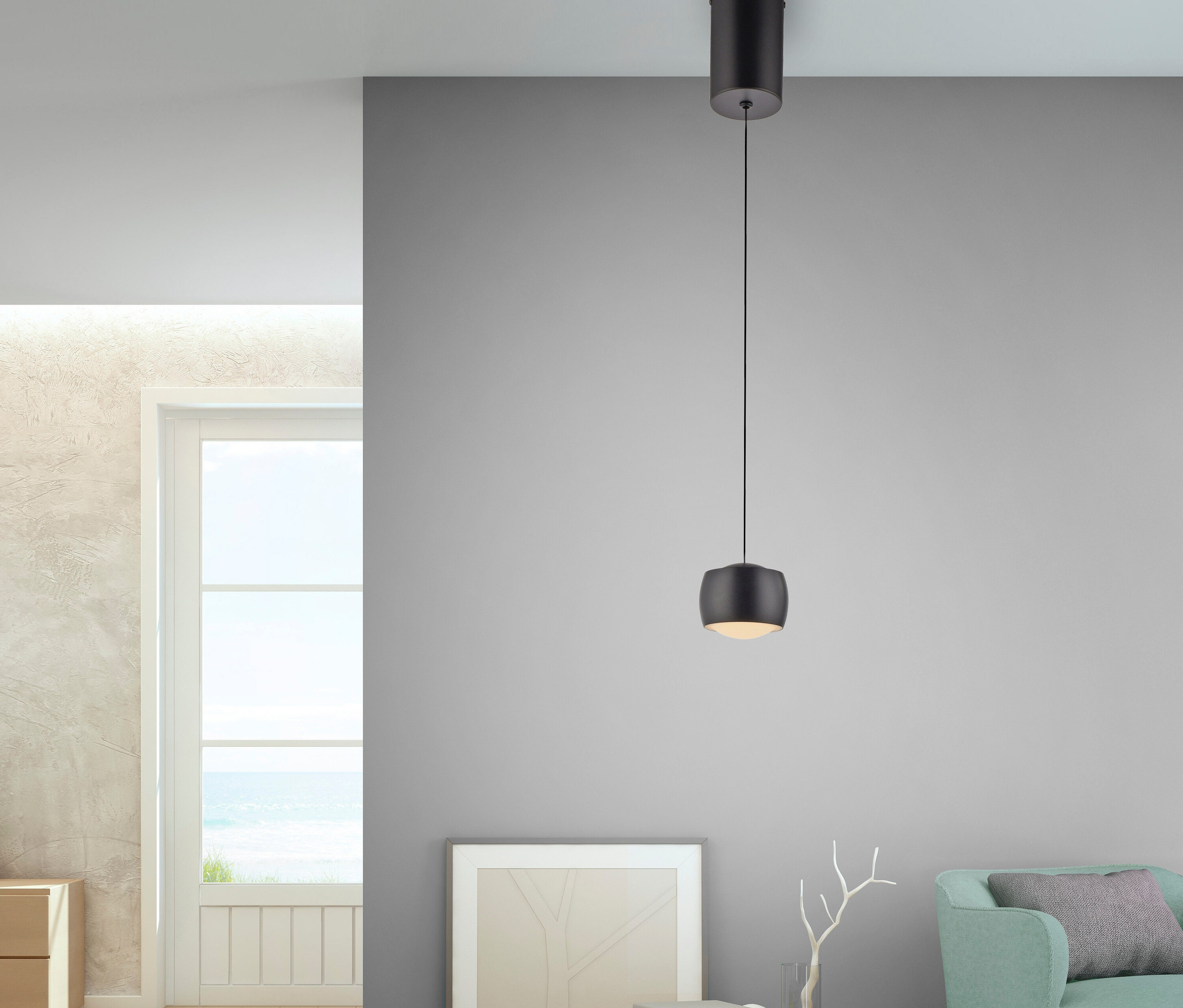 Eine schwarze Hängelampe hängt von der Decke in einem Wohnzimmer.