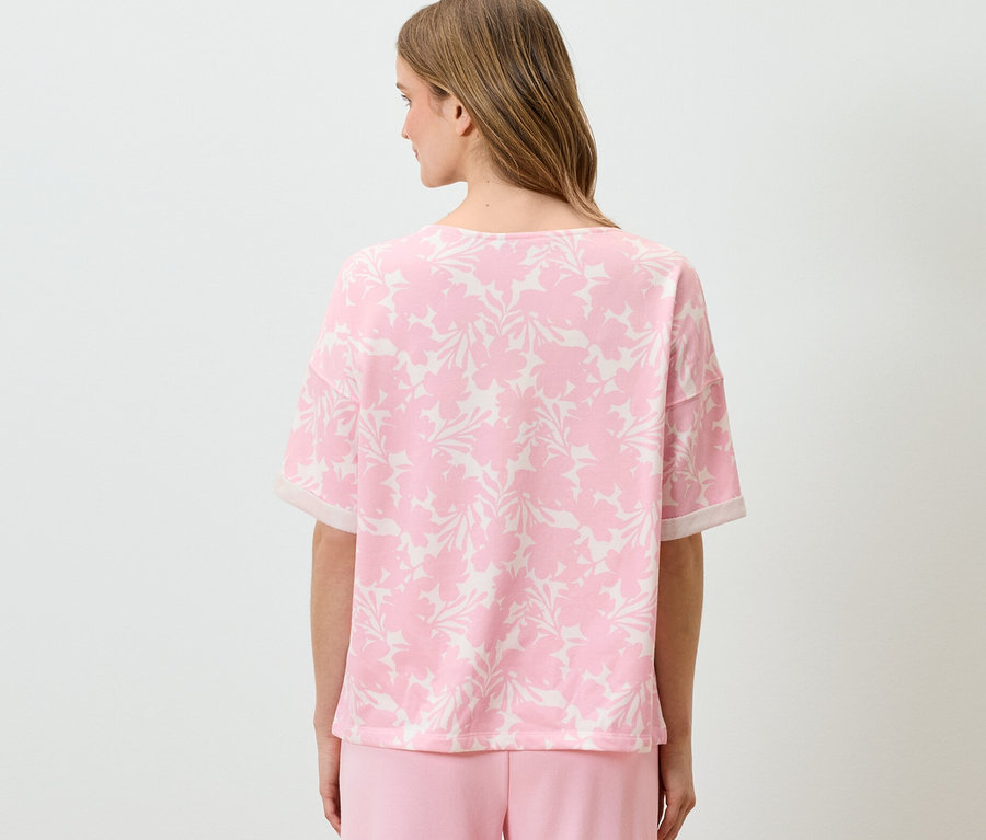 Frau trägt ein bedrucktes Sweatshirt in Rosé.
