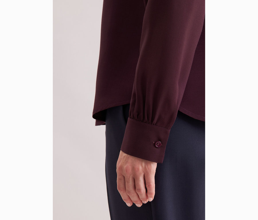 Nahaufnahme einer Frau, die eine Seidensticker Schluppenbluse aus Viskose trägt.