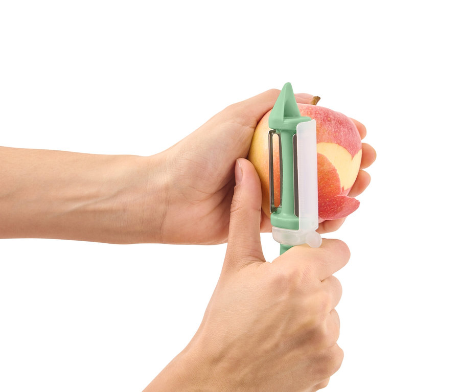 Hände schälen Apfel mit 2-in-1-Universalschäler.
