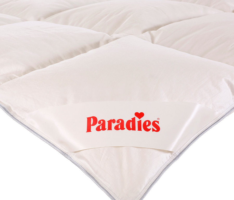 Detail einer weißen Steppdecke mit dem Paradies-Logo. Paradies Ganzjahres-Daunendecke »Hoheluft«, Übergröße ist sichtbar.