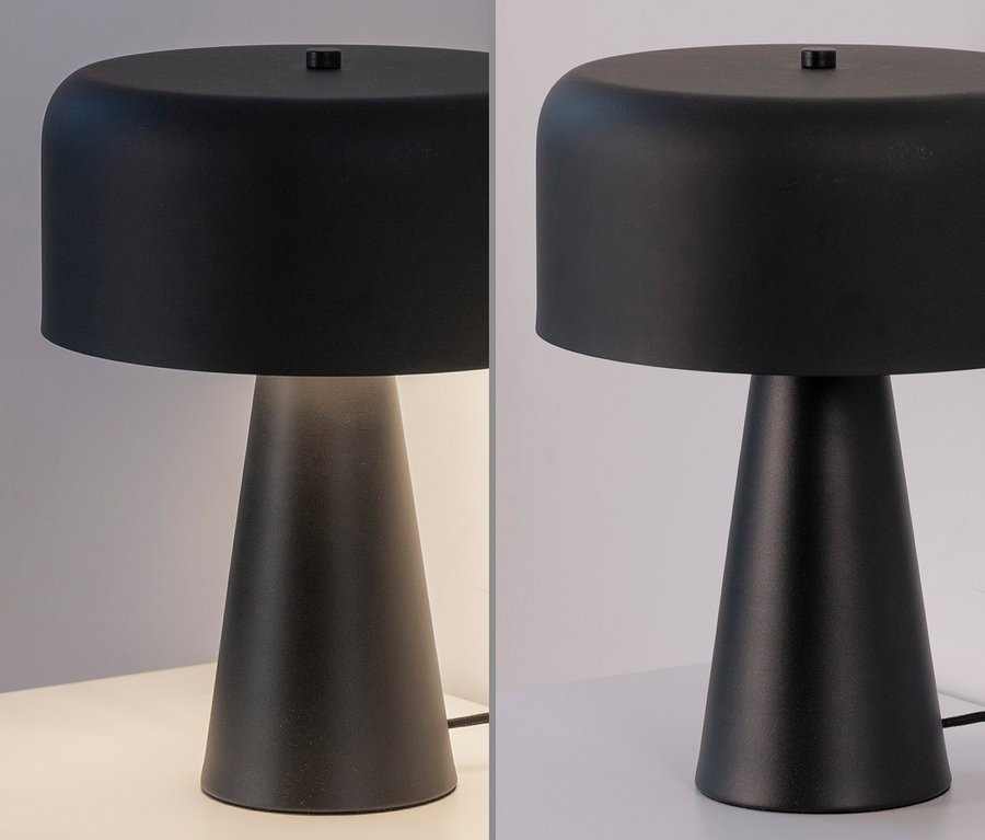 Eine schwarze Tischlampe steht auf einem weißen Tisch.