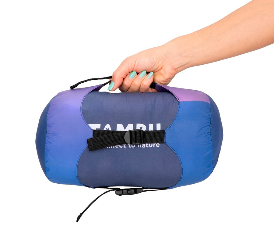 Eine Hand hält einen lila-blauen verpackten Tambu Mumienschlafsack »SANGU 600«.
